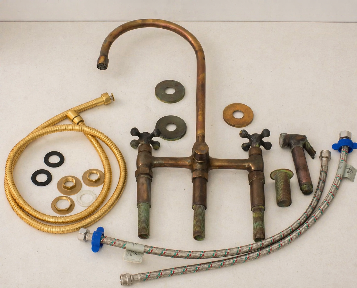 Aged brass bridge kitchen faucet with side sprayer, hoses and installation components