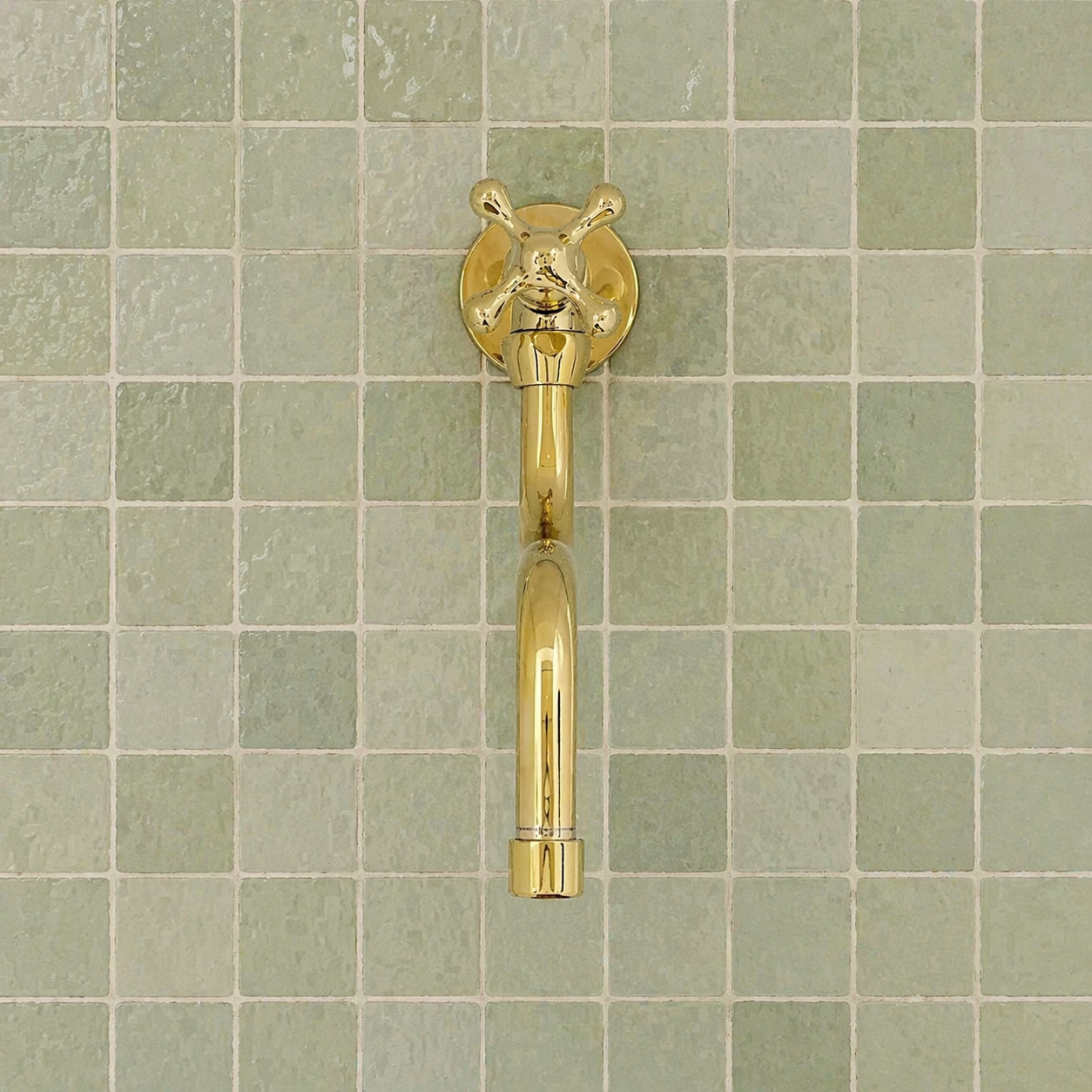 Handmade solid brass wall-mounted pot filler faucet with a swiveling neck and unlacquered living brass finish installed above a kitchen stove.