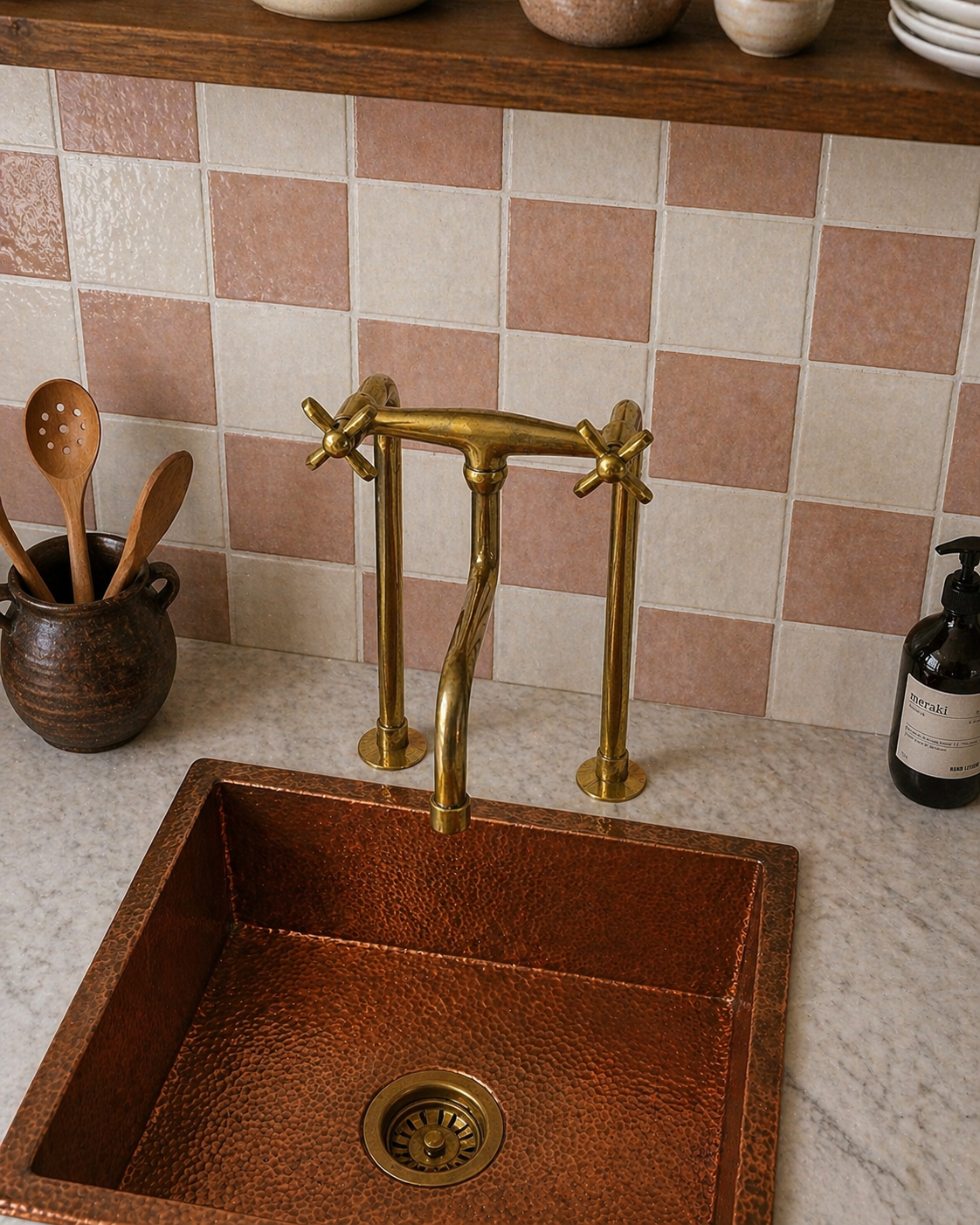 Tall unlacquered brass bridge kitchen faucet with long linear legs, cross handles and curved spout