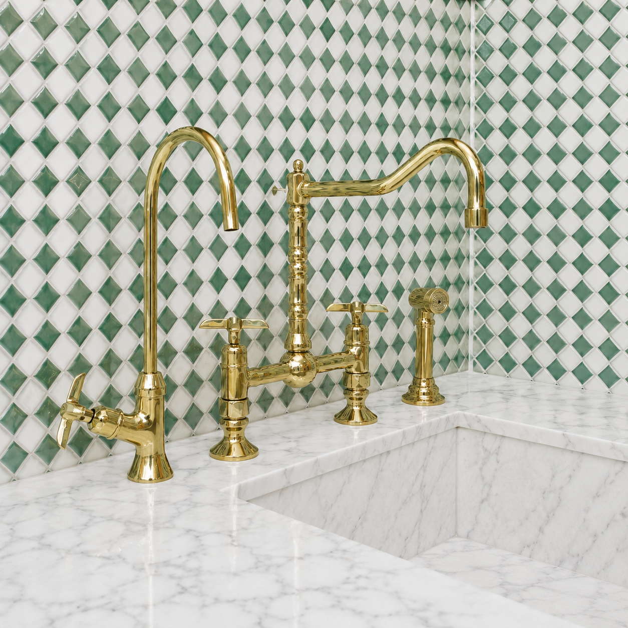 A polished brass bridge faucet set installed on a white marble sink, set against a green and white diamond-patterned tile backsplash.