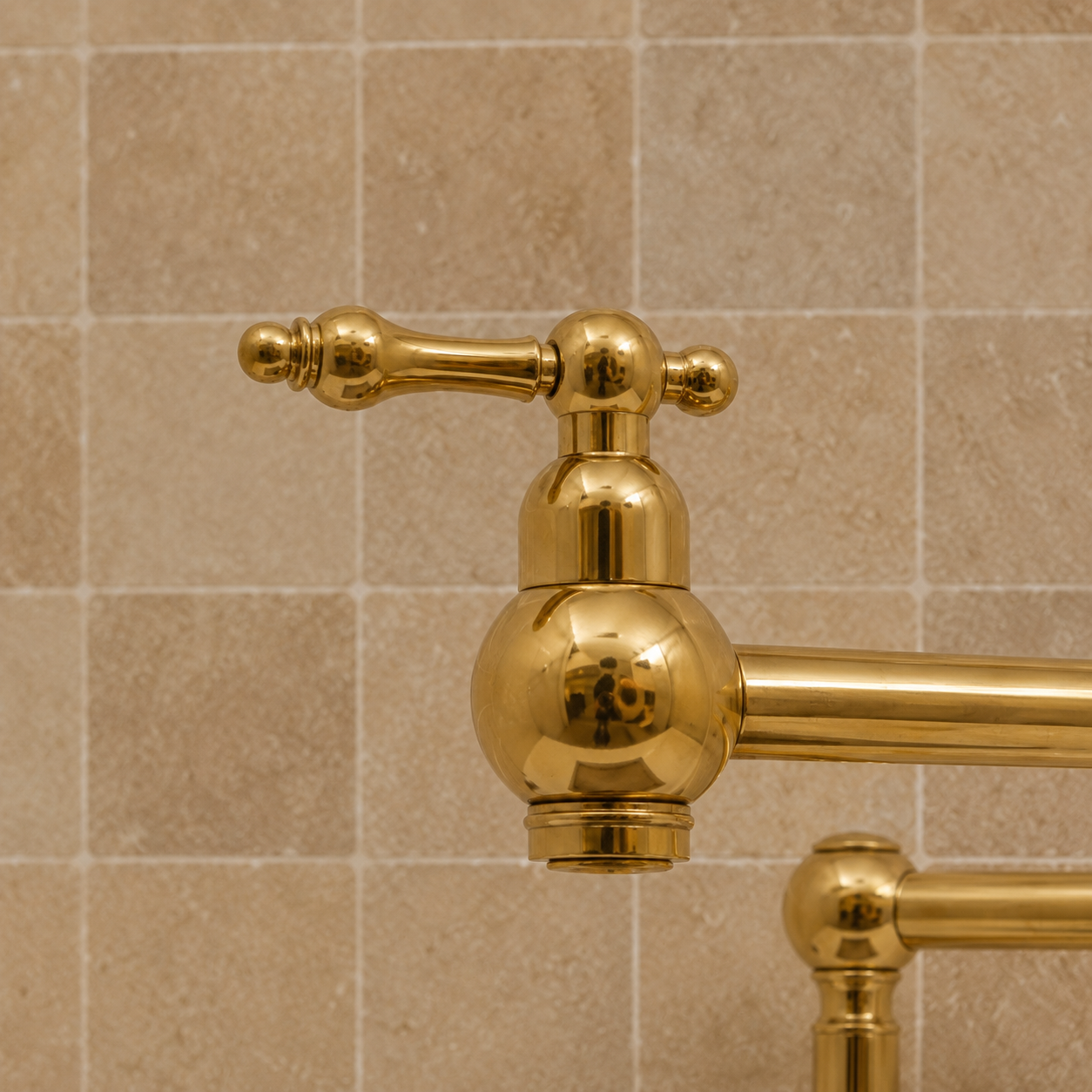 Handmade freestanding unlacquered solid brass deck-mounted pot filler faucet with double swing arms and dual lever handles installed beside a marble kitchen sink.