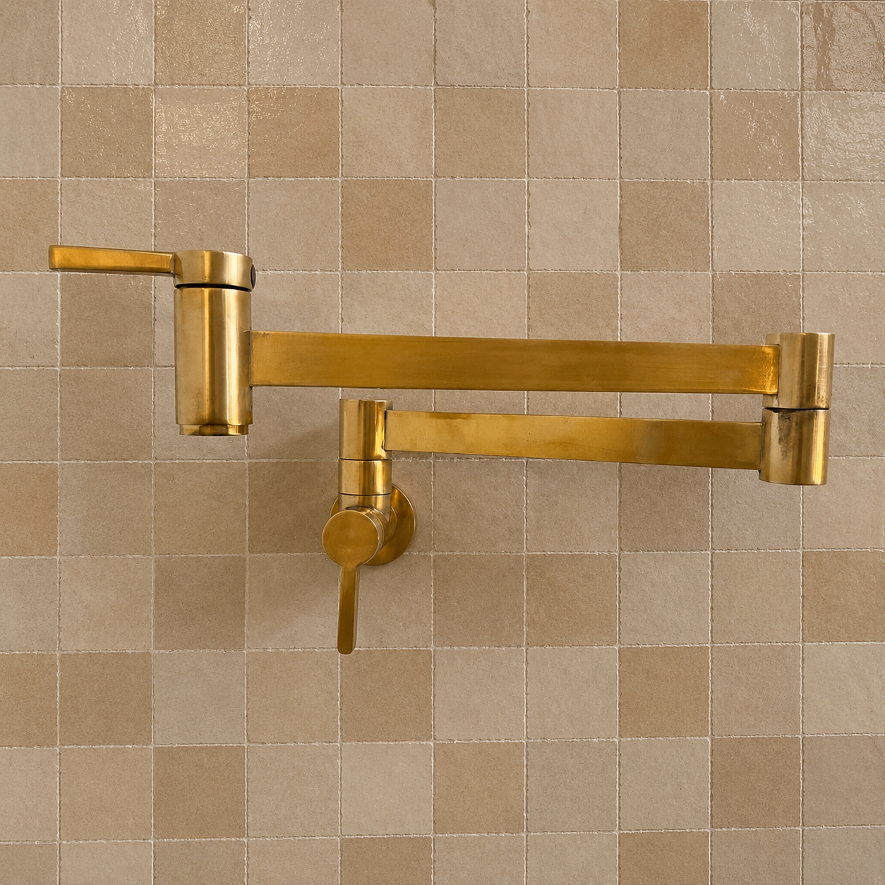 Modern handmade unlacquered solid brass wall-mounted pot filler faucet with dual swing arms and minimalist design for luxury kitchens.