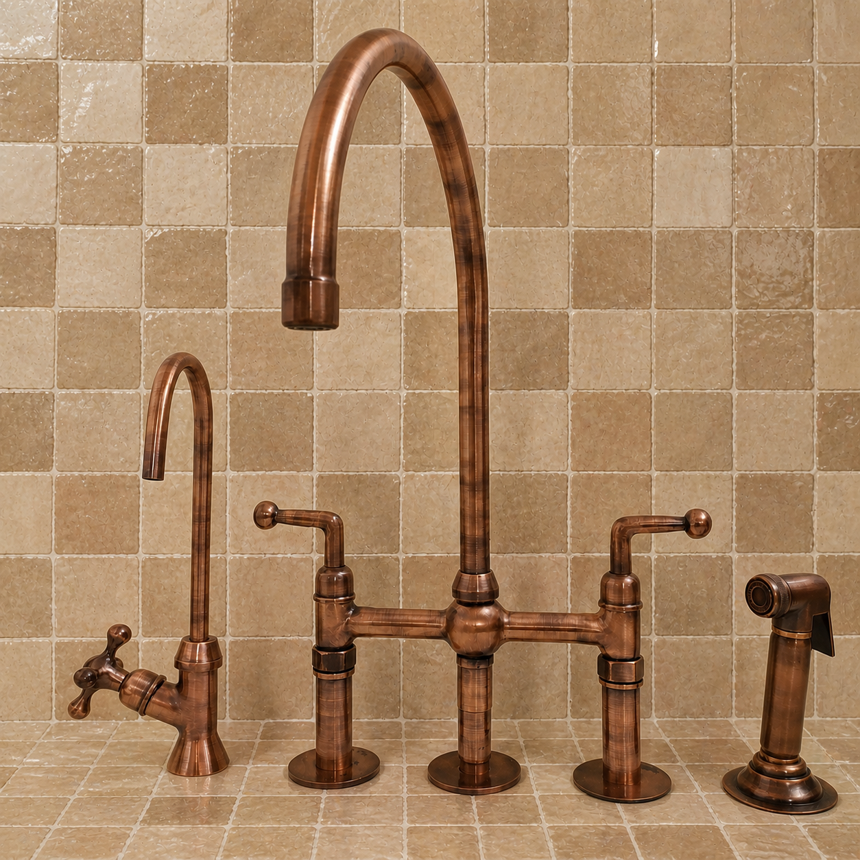 A three-hole bridge faucet set in a warm copper/bronze finish, shown with a tall gooseneck spout, a smaller side spout, a handheld sprayer, and a cross-handle valve trim against a beige tiled backsplash.