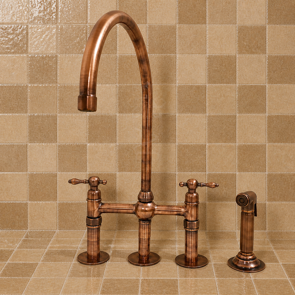 An antique bronze bridge faucet set with a high-arc spout, two separate handles, and a matching side sprayer, shown installed against a beige checkered tile backsplash.
