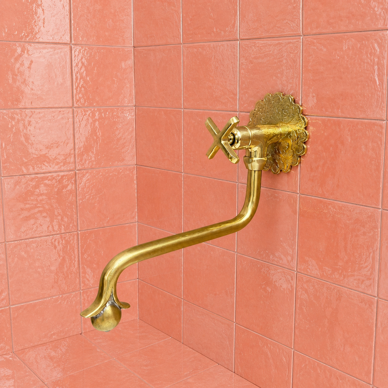 Handmade unlacquered solid brass wall-mounted pot filler faucet with curved swan-neck spout and engraved Moroccan decorative backplate.