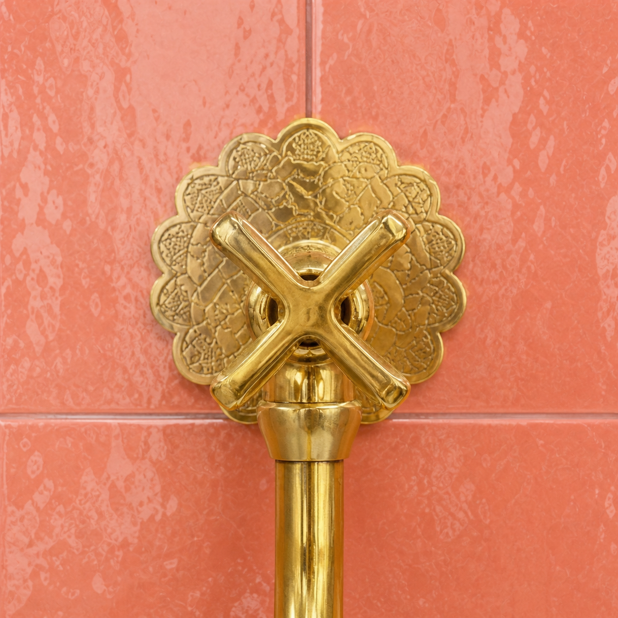 Handmade unlacquered solid brass wall-mounted pot filler faucet with curved swan-neck spout and engraved Moroccan decorative backplate.