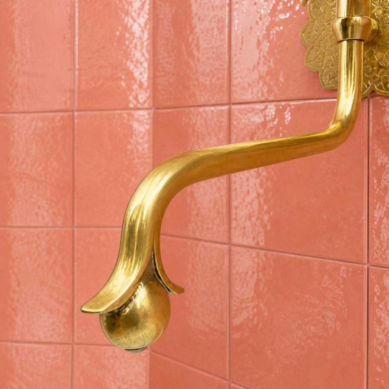 Handmade unlacquered solid brass wall-mounted pot filler faucet with curved swan-neck spout and engraved Moroccan decorative backplate.