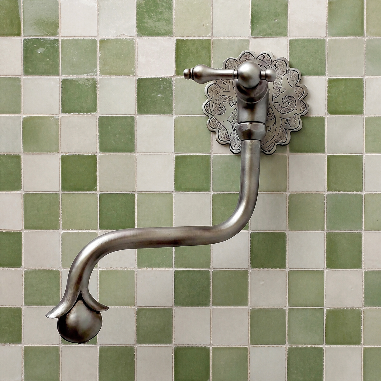 Handmade brushed nickel solid brass wall-mounted pot filler faucet with decorative Moroccan engraved backplate and curved swivel spout.