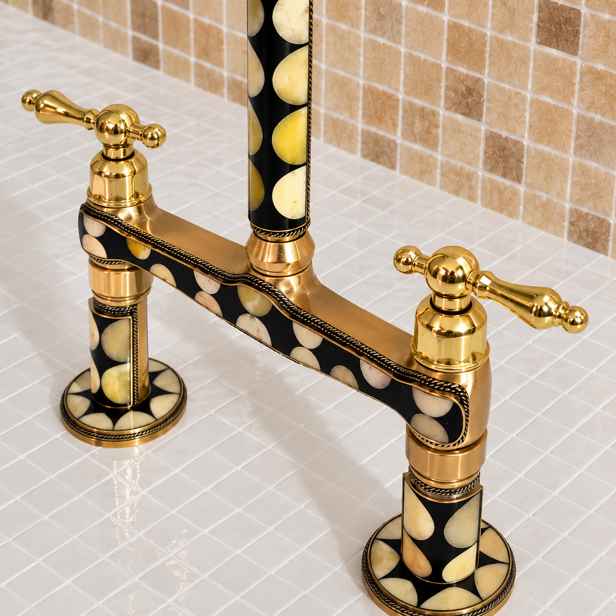 A close-up of a two-handle bridge faucet with polished gold-tone metal and black-and-cream patterned inlay, shown installed on a tiled kitchen sink.