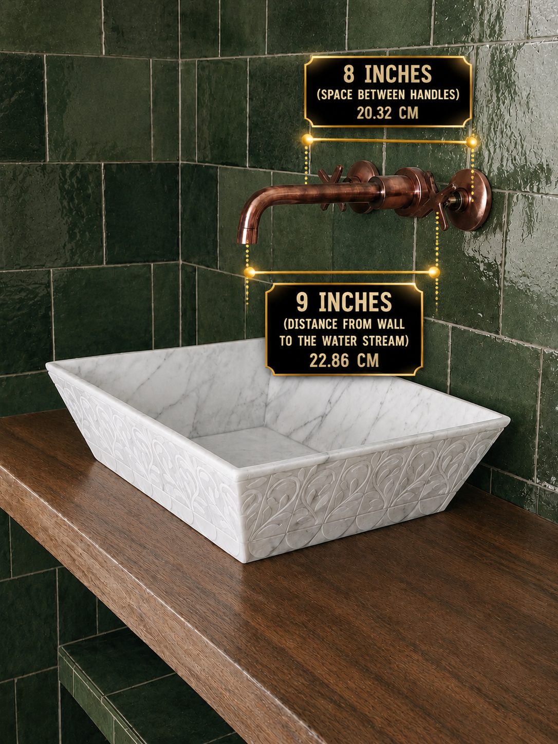 A white rectangular vessel sink with a carved floral pattern sits on a dark wood countertop against a glossy dark green tiled wall. A copper faucet is mounted above, with two black measurement labels showing 8 inches between handles and 9 inches from the wall to the water stream.