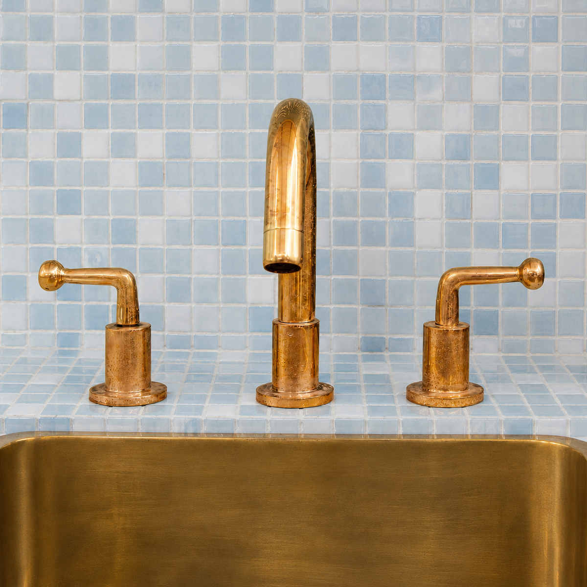 Handmade unlacquered brass widespread bathroom faucet with lever handles on a blue zellige vanity