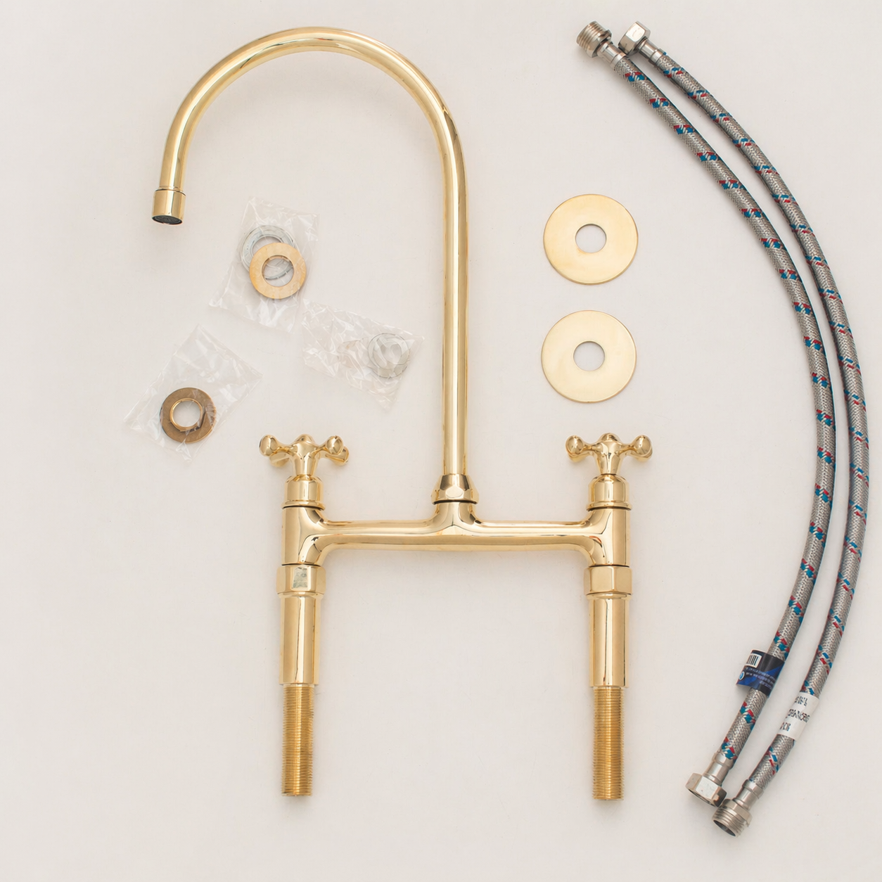 Unlacquered brass bridge kitchen faucet with cross handles, high-arc spout and installation hoses