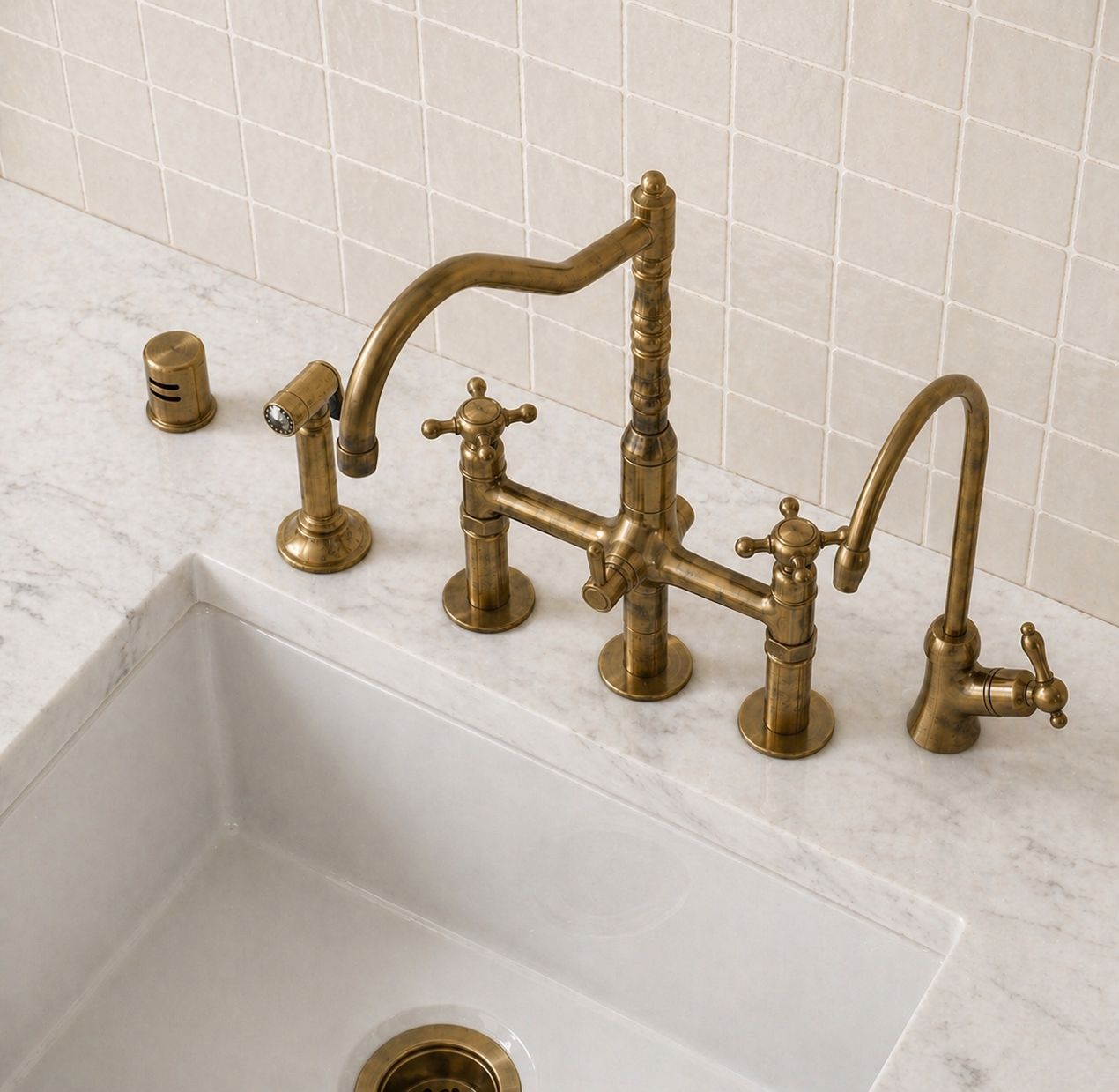 Unlacquered brass bridge kitchen faucet with cross handles and matching handheld side sprayer