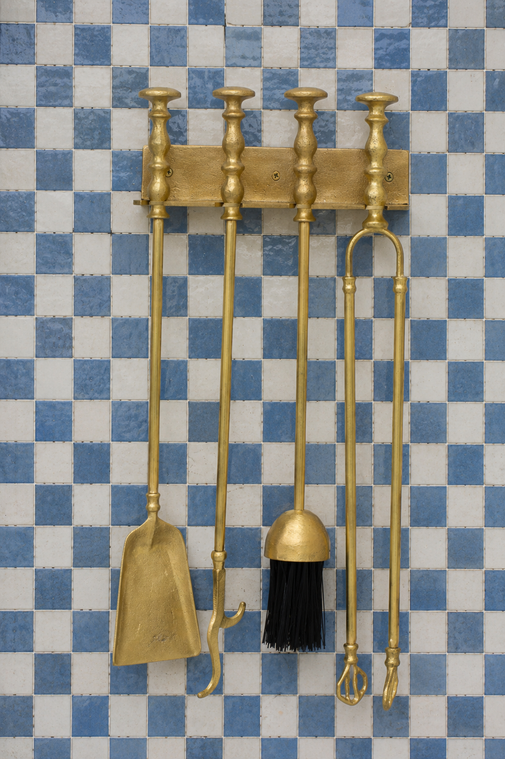 Handmade solid brass wall-mounted fireplace tool set with poker, tongs, ash shovel, brush, and storage rack.