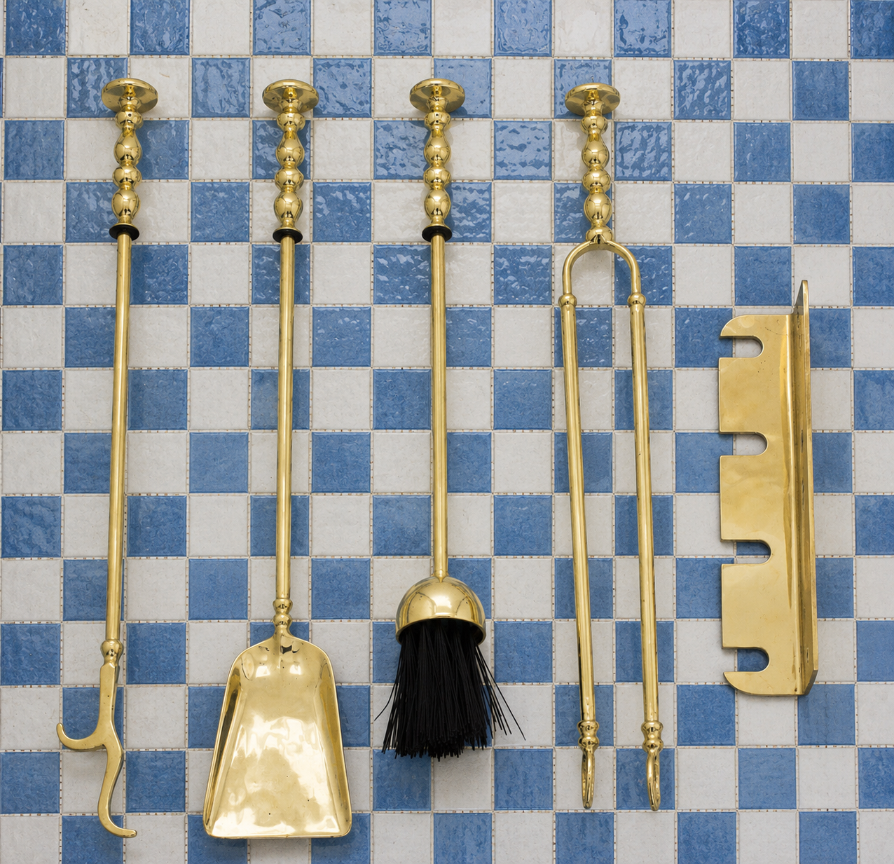 Handmade solid brass wall-mounted fireplace tool set with poker, tongs, ash shovel, brush, and storage rack.