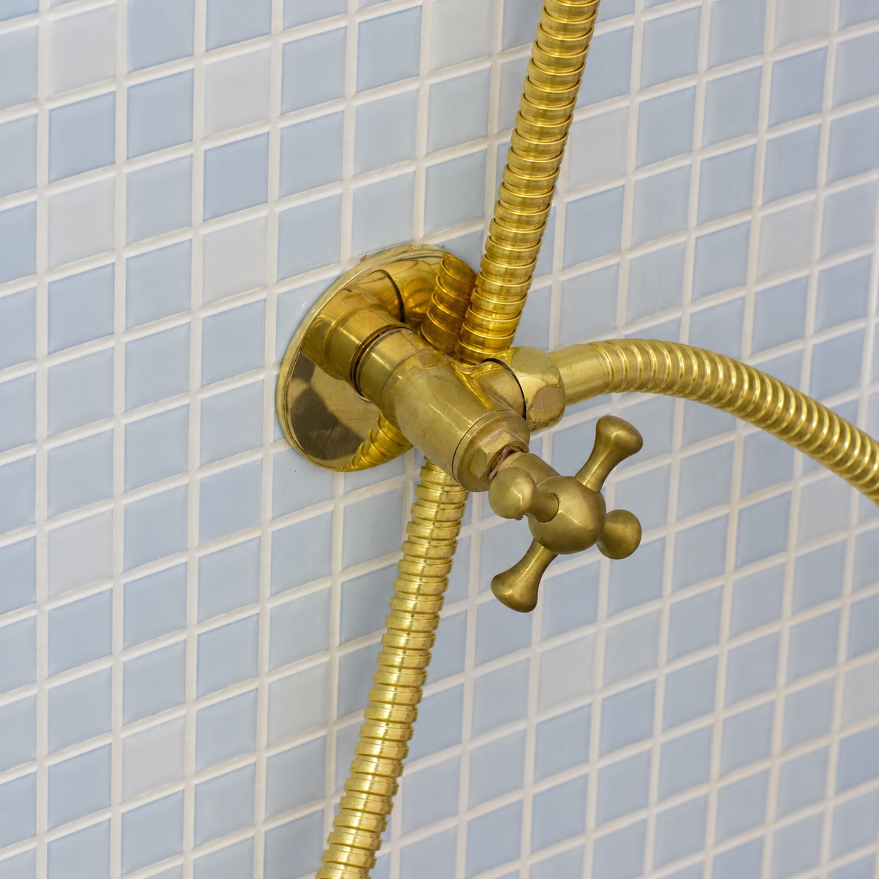 Handmade solid brass wall-mounted handheld bidet sprayer with flexible brass hose and integrated shut-off valve.