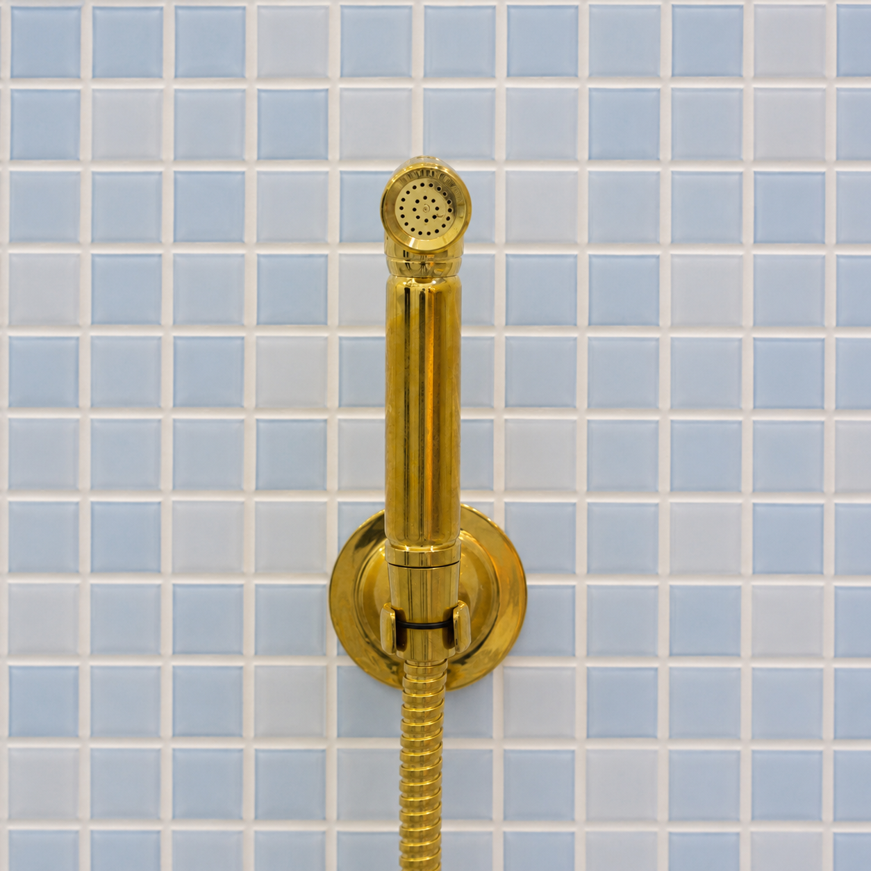 Handmade solid brass wall-mounted handheld bidet sprayer with flexible brass hose and integrated shut-off valve.
