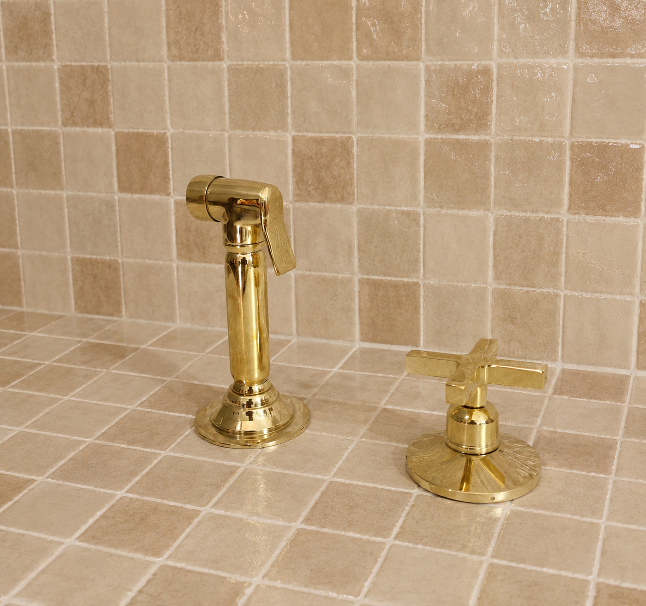 Handmade solid brass kitchen side sprayer with unlacquered finish and shut-off handle installed beside a kitchen faucet.