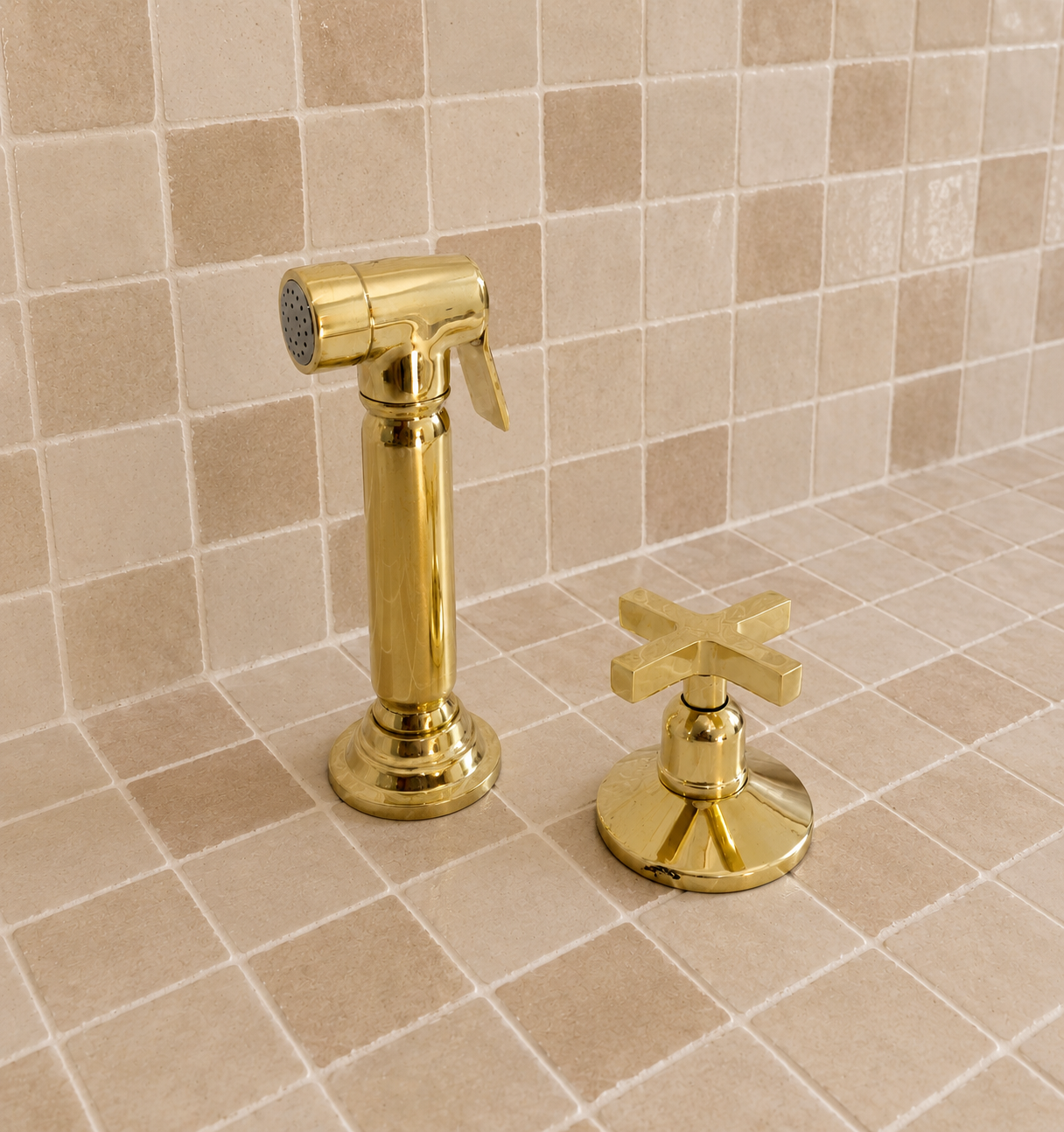 Handmade solid brass kitchen side sprayer with unlacquered finish and shut-off handle installed beside a kitchen faucet.