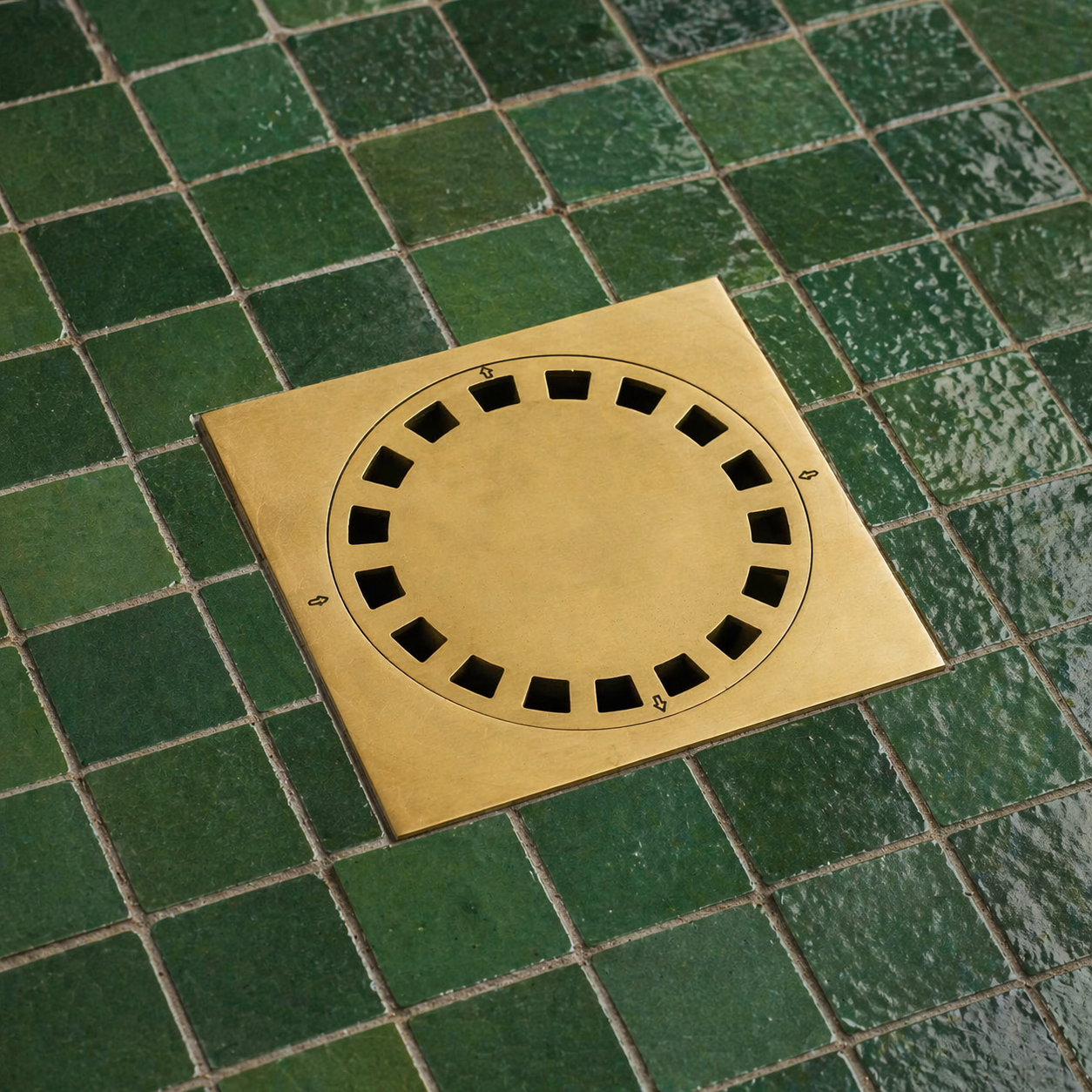 Handmade solid brass square shower floor drain with an unlacquered finish installed in a tiled shower floor.