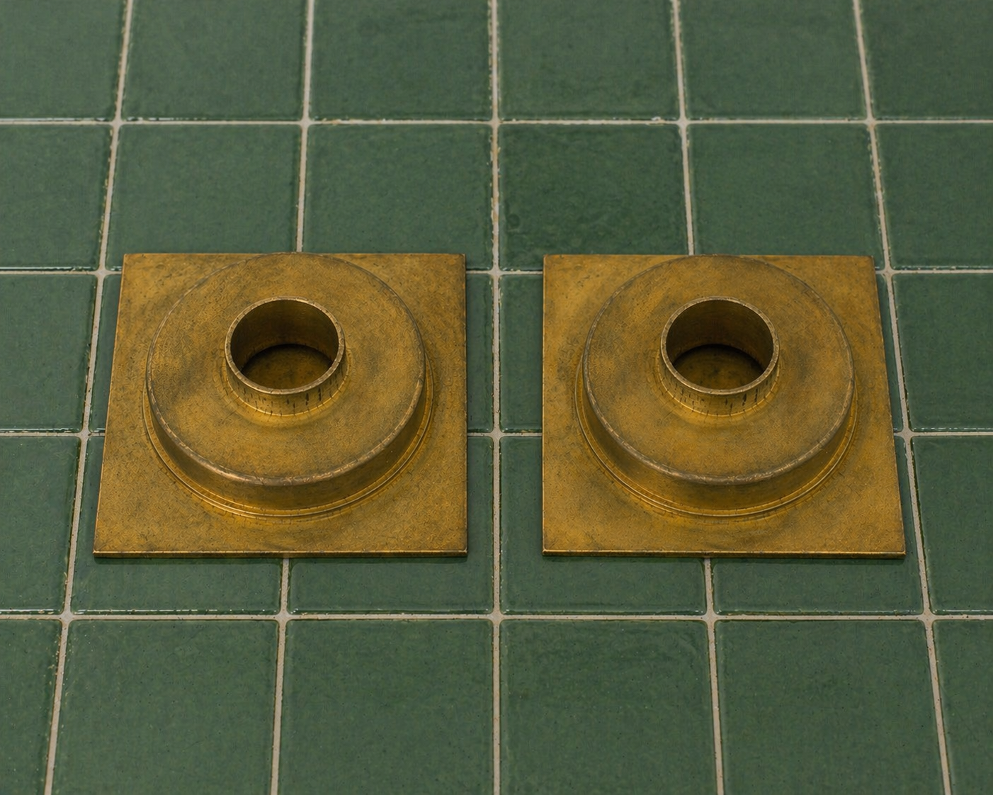 Handmade solid brass square shower floor drain with an unlacquered finish installed in a tiled shower floor.