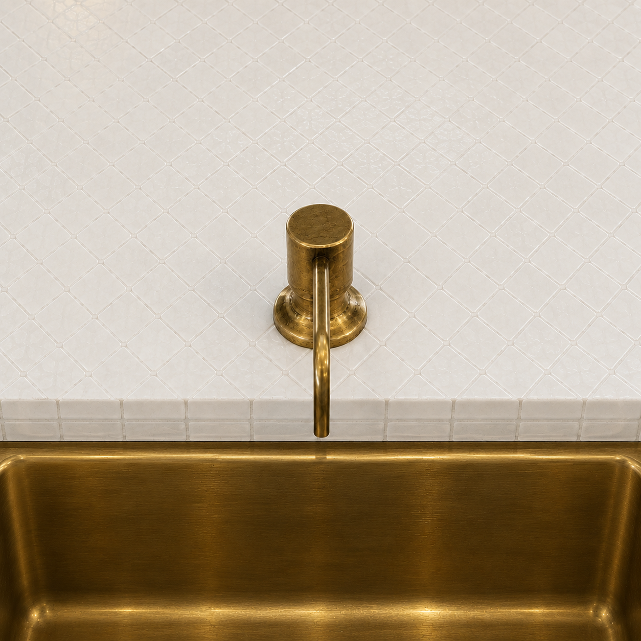 Handcrafted solid brass built-in sink soap dispenser installed on a countertop beside a brass kitchen sink.